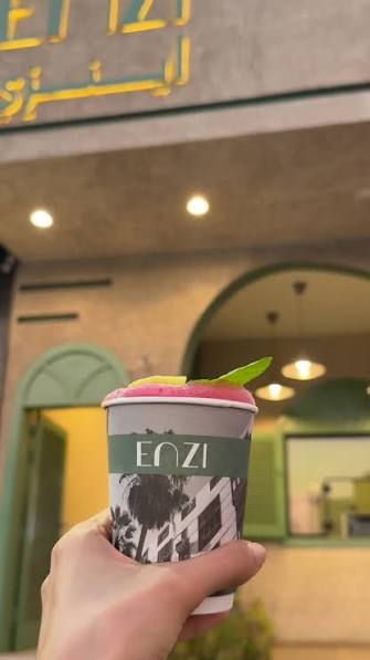 كوب enzi أمام الفرع بواجهته الخضراء